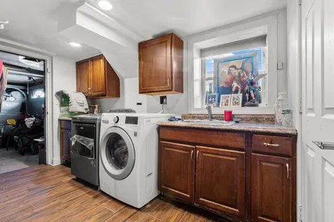 a utility room with wooden floor washer and dryer