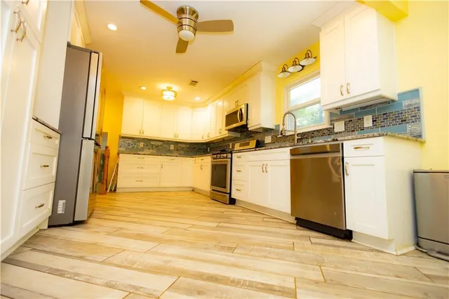 a kitchen with stainless steel appliances a stove a refrigerator and a microwave