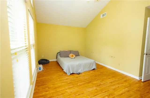 a bedroom with a bed and wooden floor