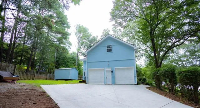a view of a house with a backyard and a tree