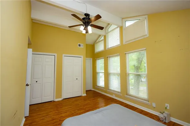 a bedroom with a bed and wooden floor