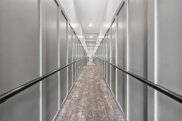 a view of a hallway with wooden floor and stairs