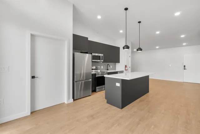 a kitchen with stainless steel appliances kitchen island a large counter top and a sink