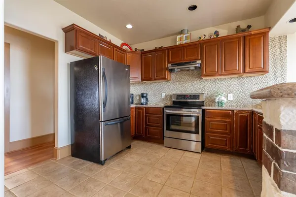 a kitchen with stainless steel appliances granite countertop a stove a sink and a microwave
