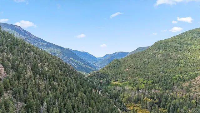 a view of a dry yard with mountains in the background