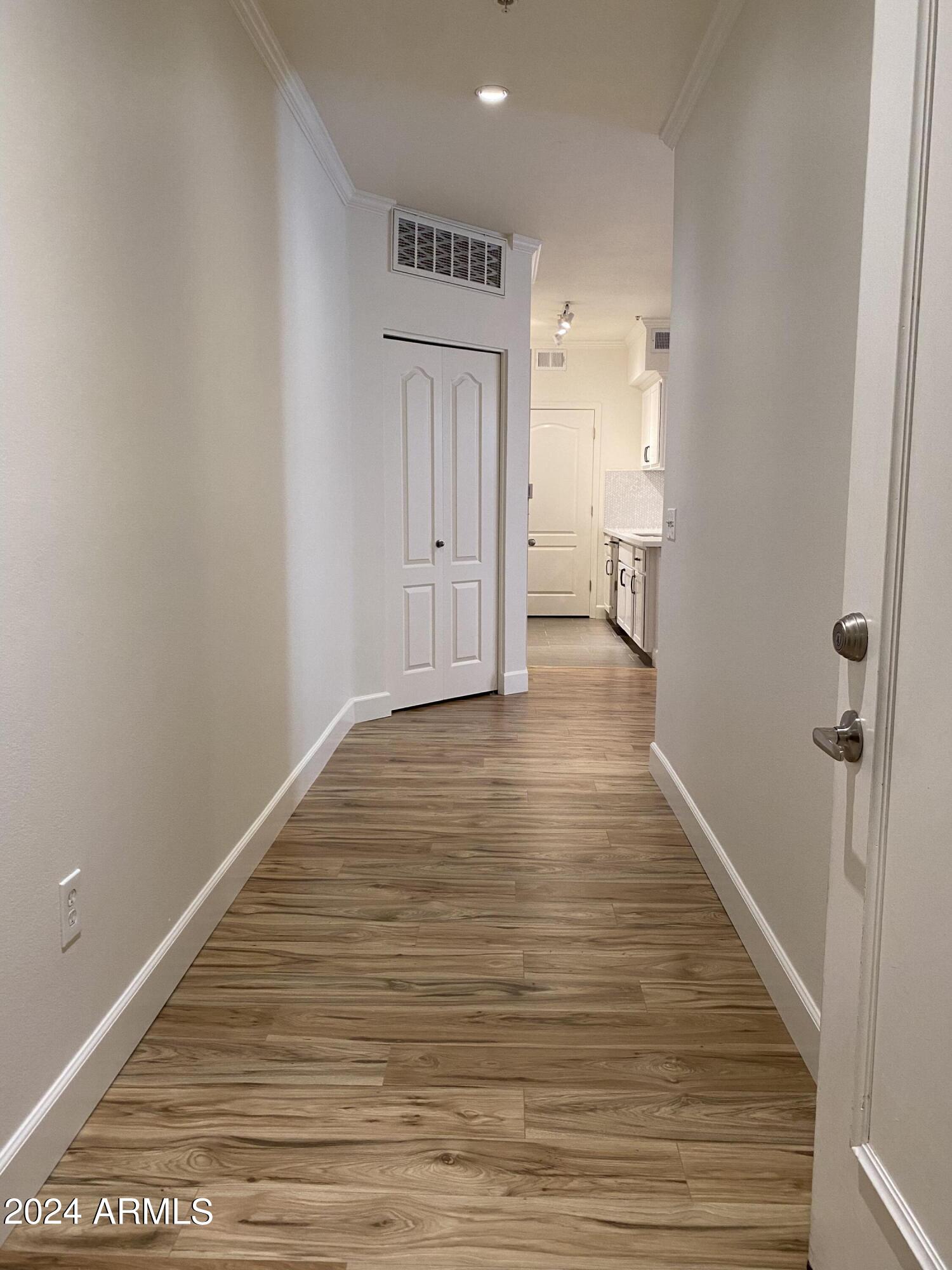 1701 East Colter Street, Unit 215 Phoenix, AZ 85016 - Photo 2 of 28 a view of a hallway with wooden floor and a bathroom