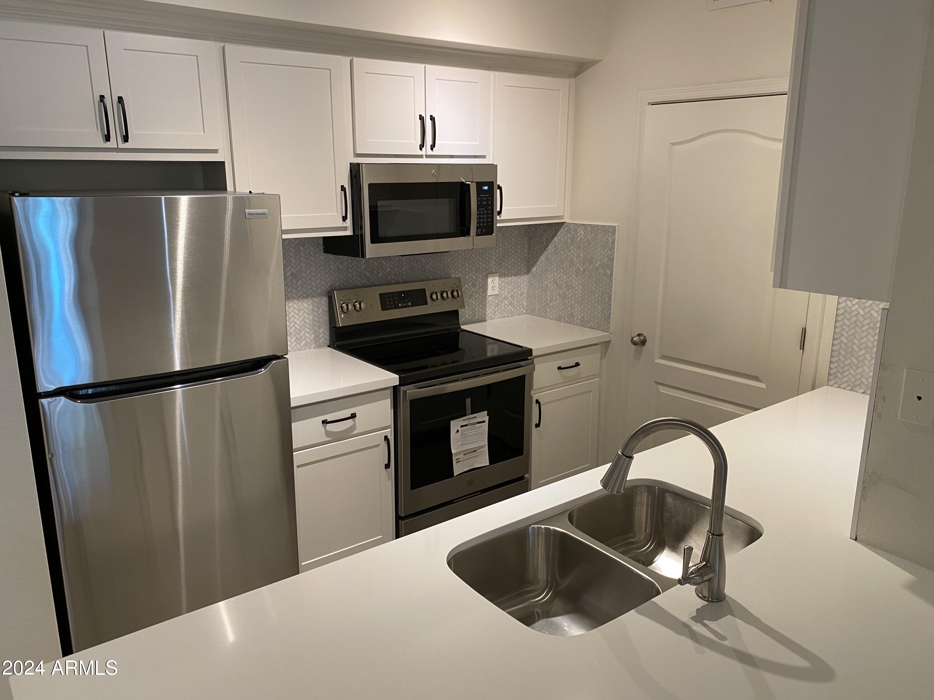 1701 East Colter Street, Unit 215 Phoenix, AZ 85016 - Photo 3 of 28 a kitchen with stainless steel appliances a refrigerator sink and microwave