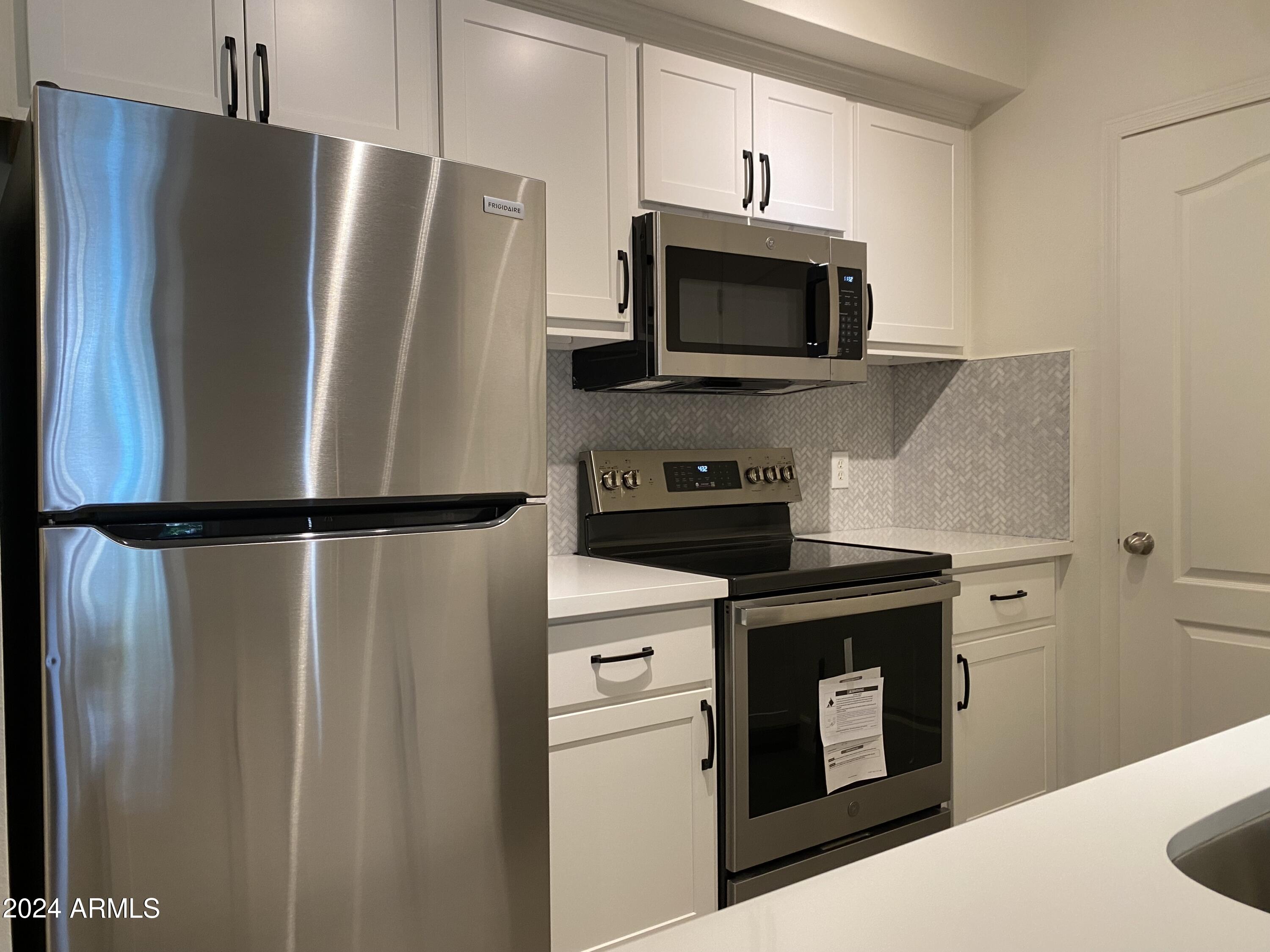 1701 East Colter Street, Unit 215 Phoenix, AZ 85016 - Photo 4 of 28 a kitchen with cabinets and stainless steel appliances