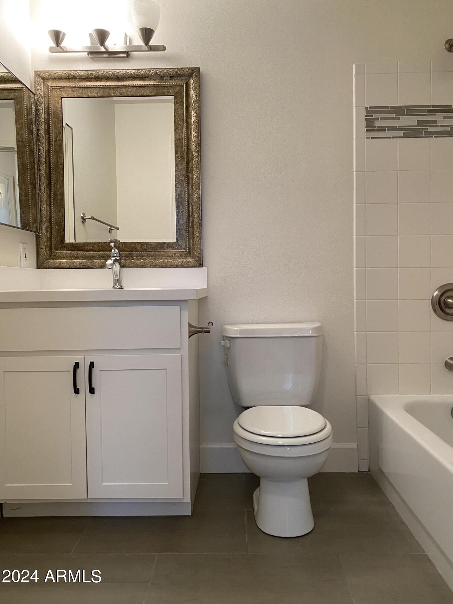 1701 East Colter Street, Unit 215 Phoenix, AZ 85016 - Photo 9 of 28 a bathroom with a toilet sink and mirror
