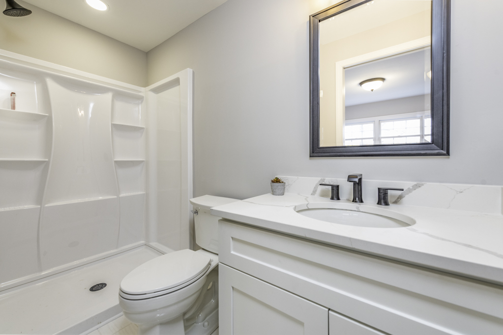 24199 West Beach Grove Road Antioch, IL 60002 - Photo 17 of 22 a bathroom with a granite countertop sink a toilet and a bathtub