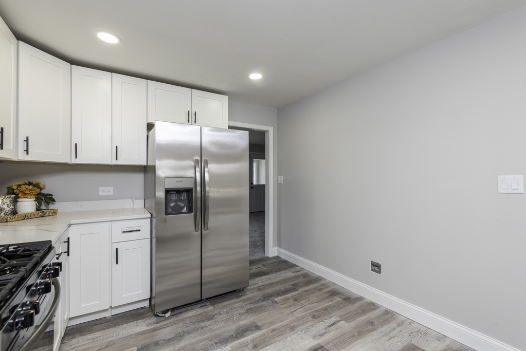24199 West Beach Grove Road Antioch, IL 60002 - Photo 5 of 22 a kitchen with granite countertop a refrigerator and a stove top oven