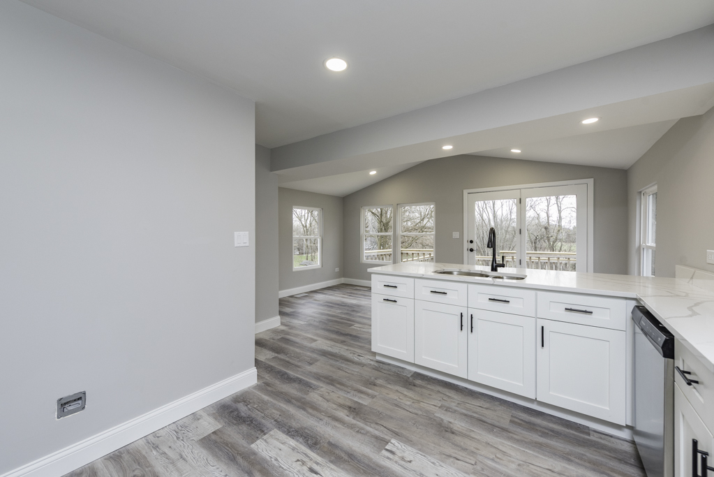 24199 West Beach Grove Road Antioch, IL 60002 - Photo 6 of 22 a large kitchen with granite countertop a stove a sink and white cabinets with wooden floor