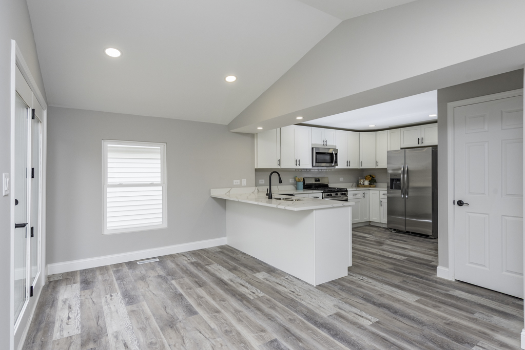 24199 West Beach Grove Road Antioch, IL 60002 - Photo 8 of 22 a kitchen with stainless steel appliances granite countertop a sink cabinets and wooden floor