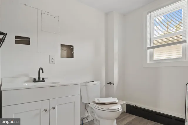 a bathroom with a sink toilet and a mirror