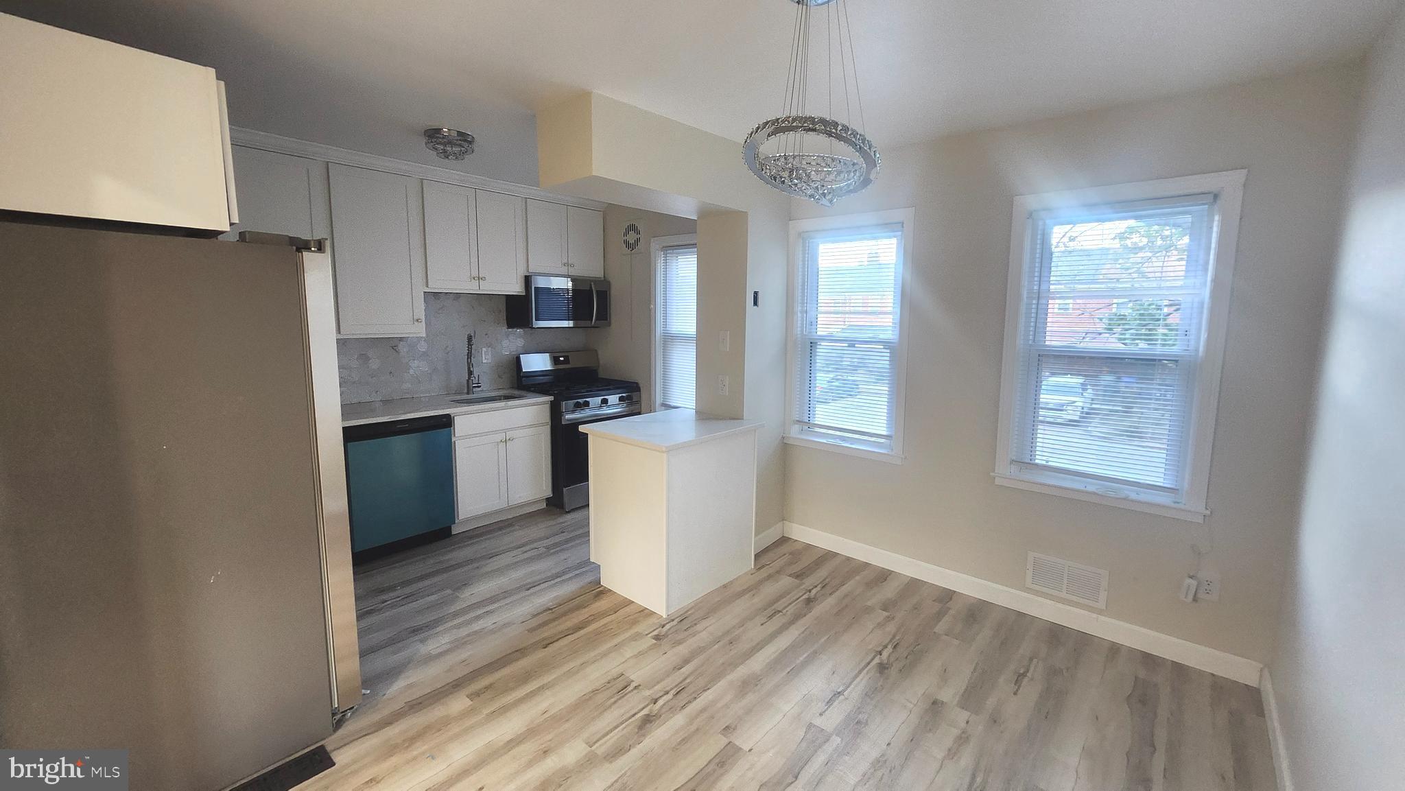 1001 Cameron Road Baltimore, MD 21212 - Photo 14 of 46 a kitchen with stainless steel appliances granite countertop a refrigerator a stove a sink and white cabinets with wooden floor
