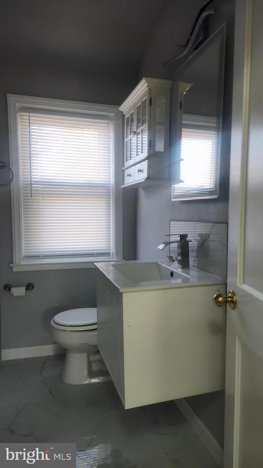 1001 Cameron Road Baltimore, MD 21212 - Photo 28 of 46 a bathroom with a toilet a sink a window and mirror