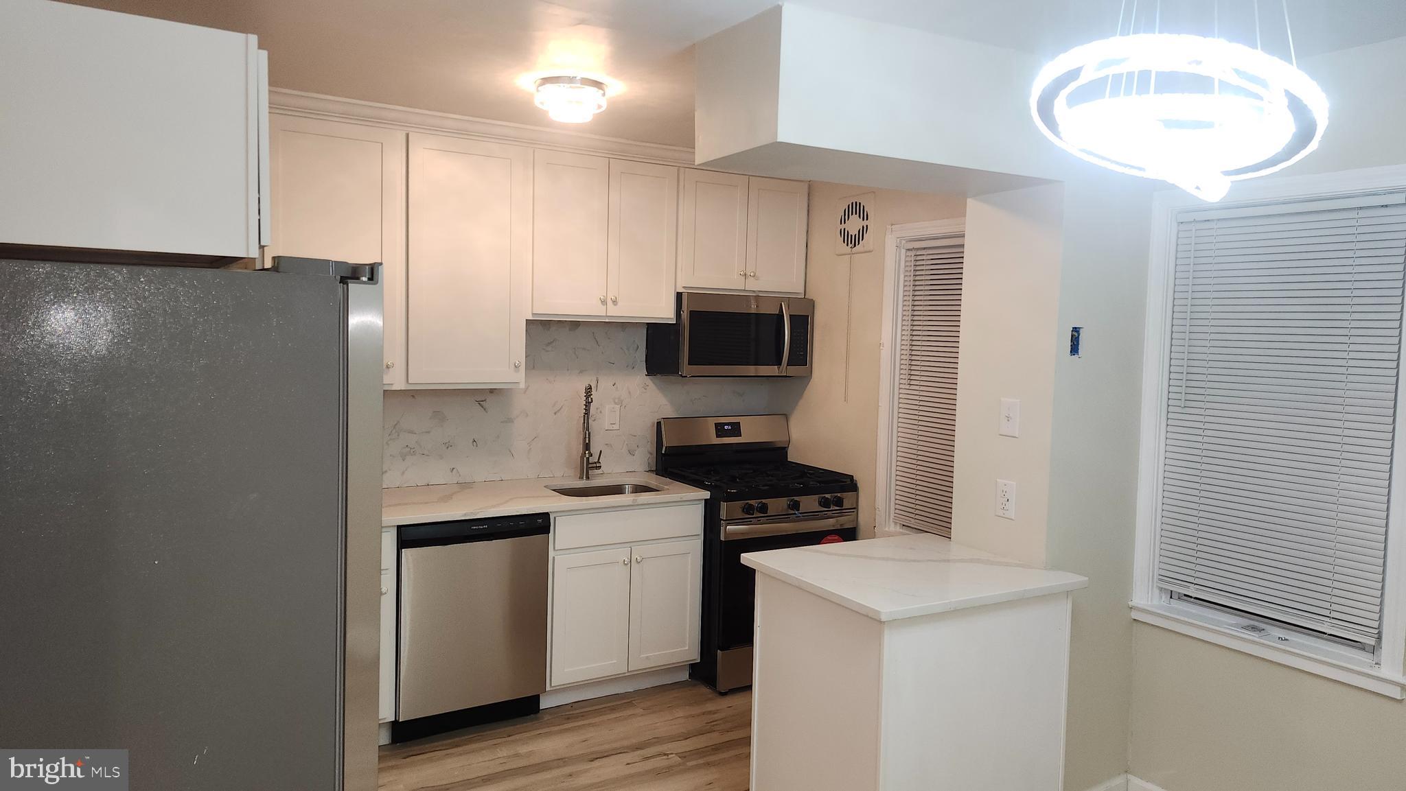 1001 Cameron Road Baltimore, MD 21212 - Photo 6 of 46 a kitchen with a sink a stove and refrigerator