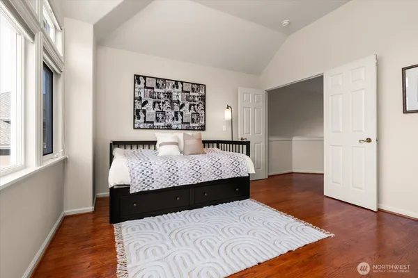 a bedroom with a large bed and wooden floor