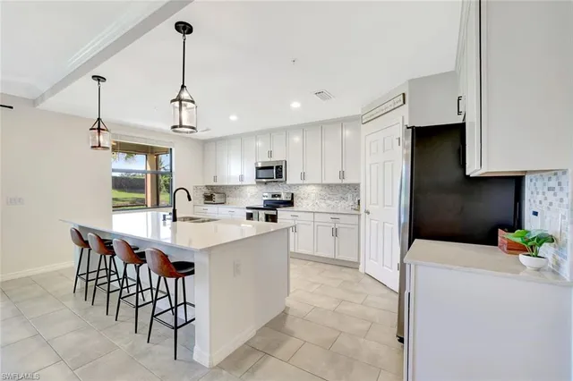 a kitchen with white cabinets stainless steel appliances and a center island