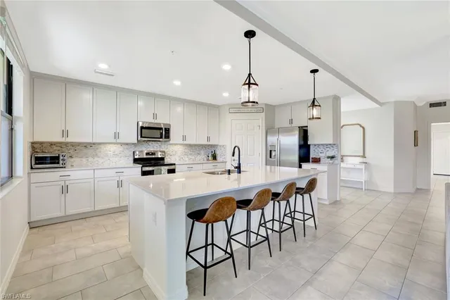 a kitchen with stainless steel appliances a sink stove and cabinets