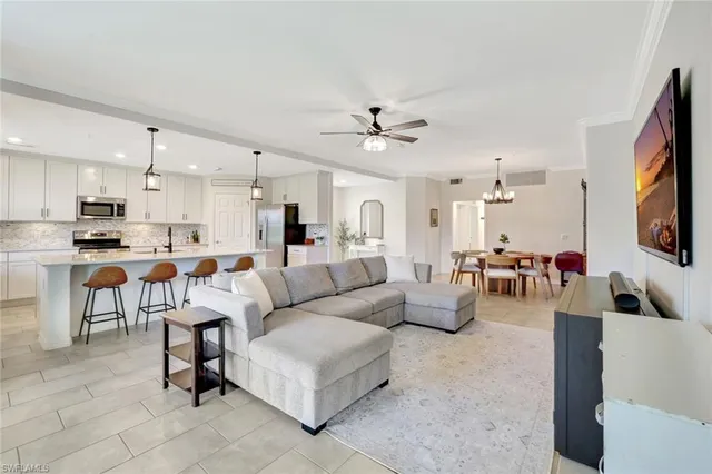 a living room with furniture kitchen view and a flat screen tv