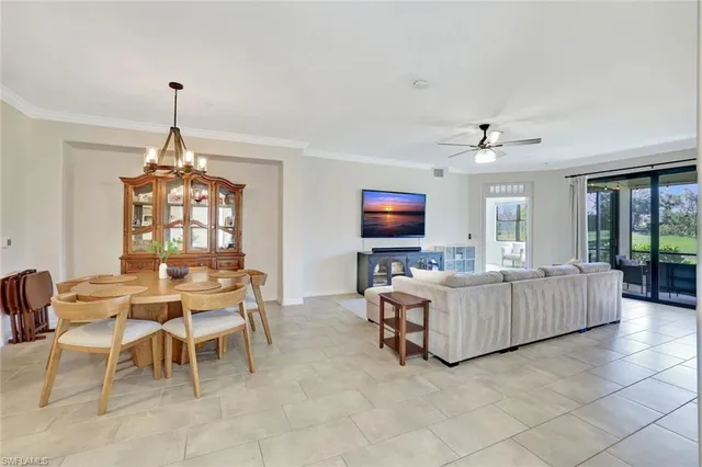 a living room with furniture a chandelier and a flat screen tv