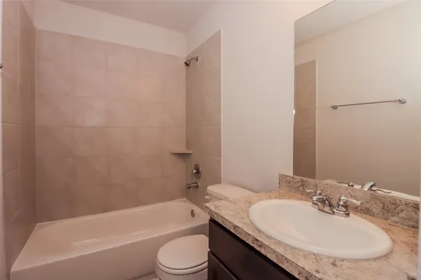 a bathroom with a granite countertop sink toilet and bathtub