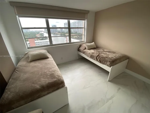 a spacious bedroom with a bed and a stand in it