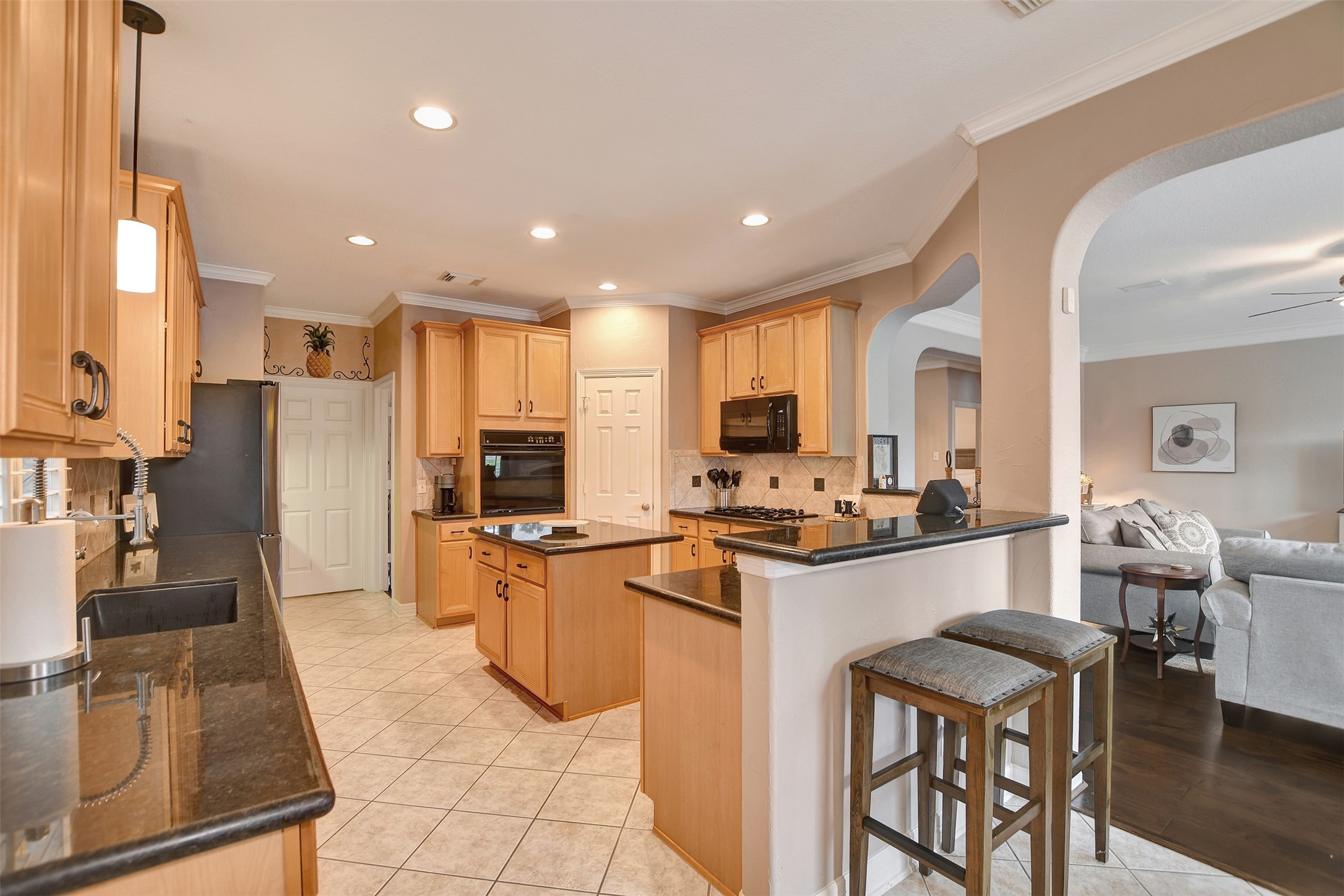 15918 Lake Loop Drive Cypress, TX 77433 - Photo 20 of 50 a kitchen with stainless steel appliances kitchen island granite countertop a stove top oven a refrigerator a sink a dining table and chairs with wooden floor