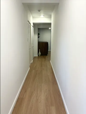 a view of a hallway with wooden floor