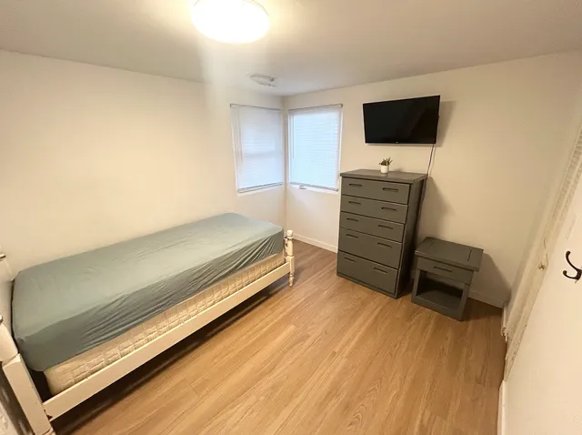 a bedroom with a bed and flat screen tv