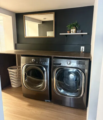 a utility room with wooden floor washer and dryer
