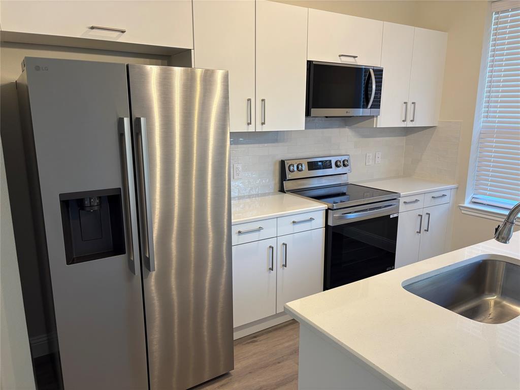 6357 Manson Court Dallas, TX 75227 - Photo 3 of 7 a kitchen with a refrigerator stove and sink