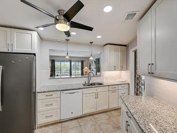 a bathroom with a granite countertop sink a toilet a mirror and shower
