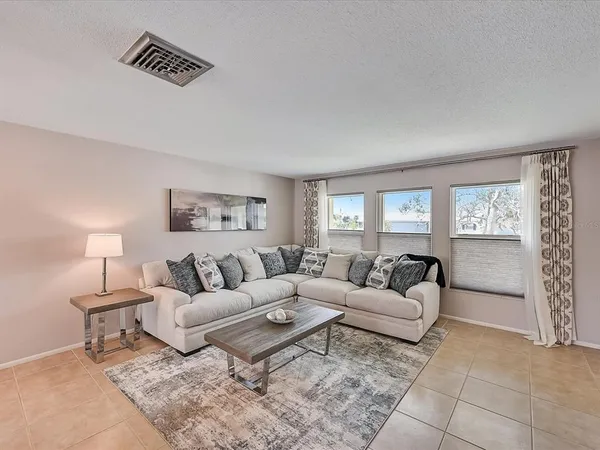 a view of a dining room with furniture a chandelier and a window