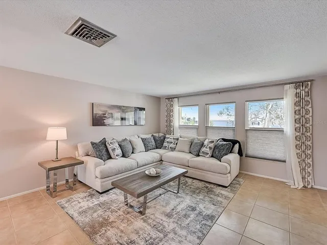 a view of a dining room with furniture a chandelier and a window