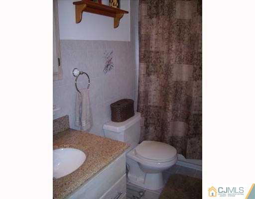 17 Finley Road Edison, NJ 08817 - Photo 8 of 10 a bathroom with a granite countertop toilet and a sink