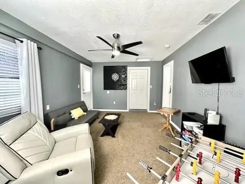 a dining room with furniture a flat screen tv and a floor to ceiling window