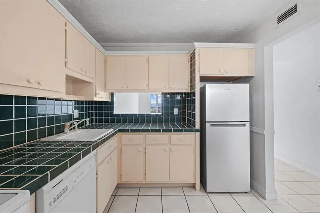a view of a kitchen with white cabinets and a stove top oven