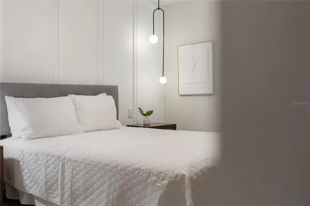 a bed room with bed and a painting on the wall