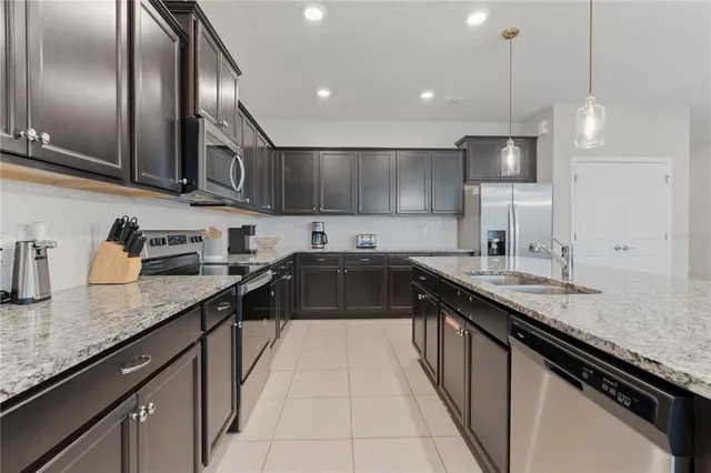 a kitchen with stainless steel appliances granite countertop a sink a stove and a refrigerator