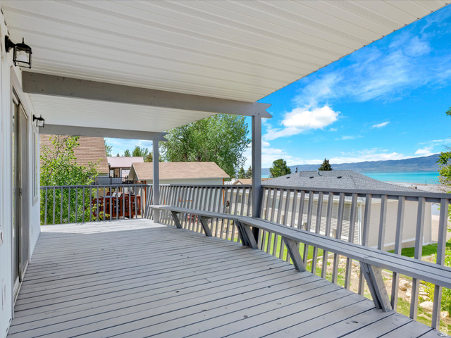 85 B Street, Unit 22 St. Charles, ID 83272 - Photo 6 of 35 Expansive covered deck featuring wood-finish flooring, a built-in bench, and perimeter railings