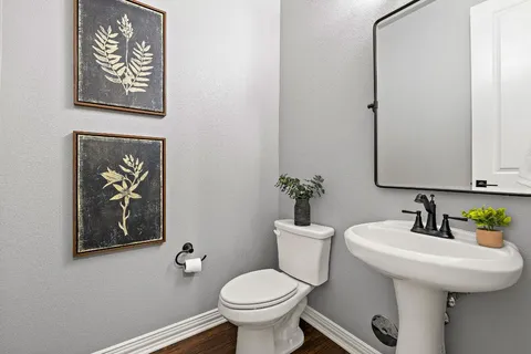 a bathroom with a toilet a sink and mirror