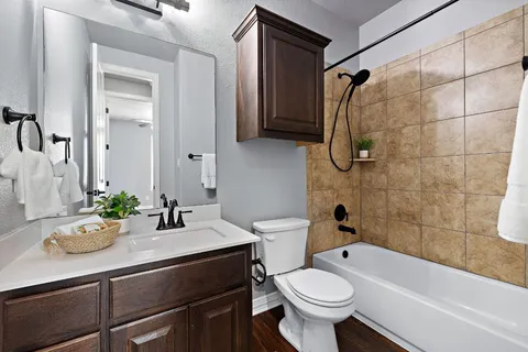 a bathroom with a sink a toilet and shower