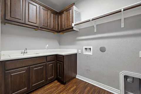 a kitchen with stainless steel appliances granite countertop a sink a microwave oven a cabinets and wooden floor