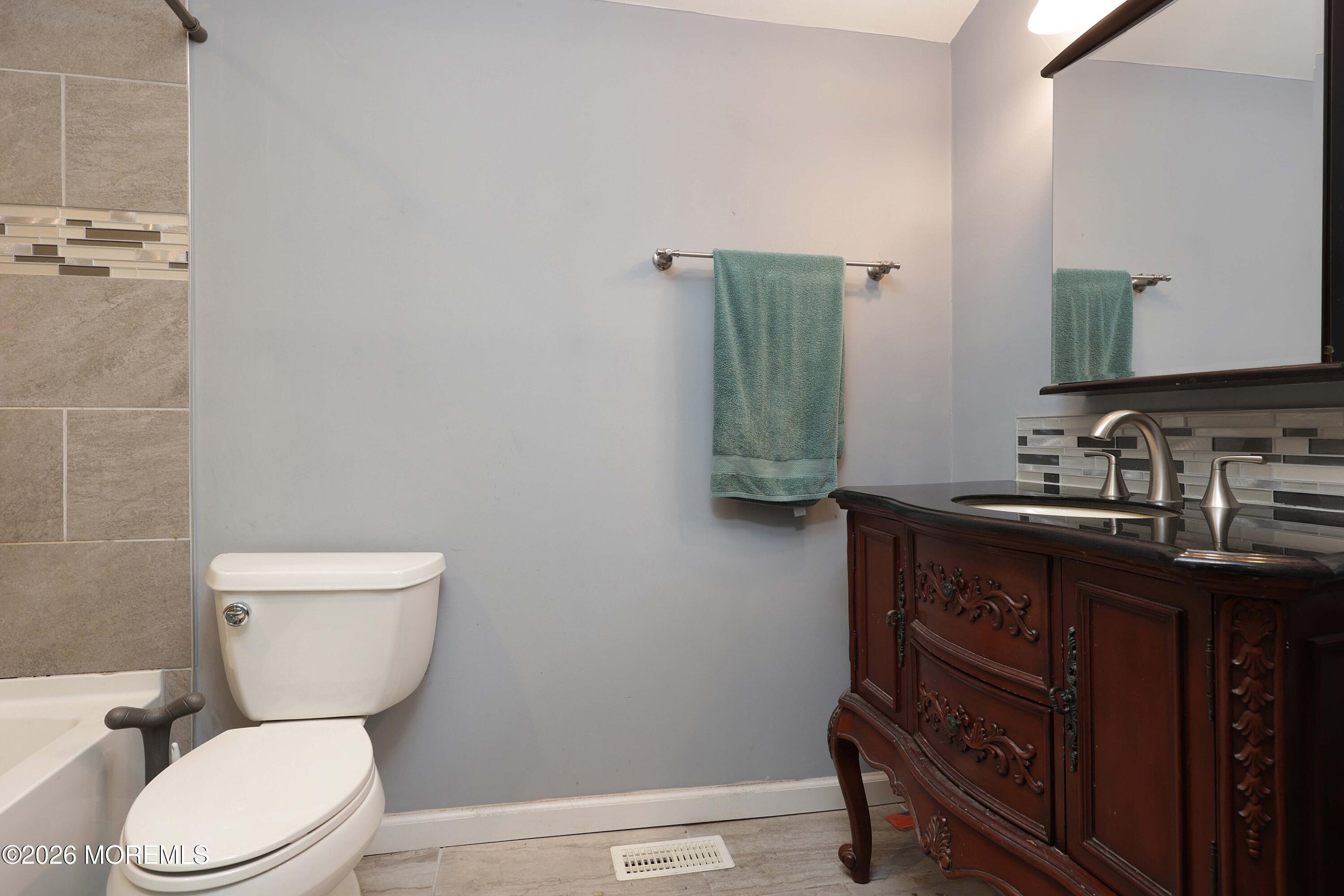 24 West Point Pleasant Avenue Ocean Gate, NJ 08740 - Photo 17 of 23 a bathroom with a toilet a sink and mirror