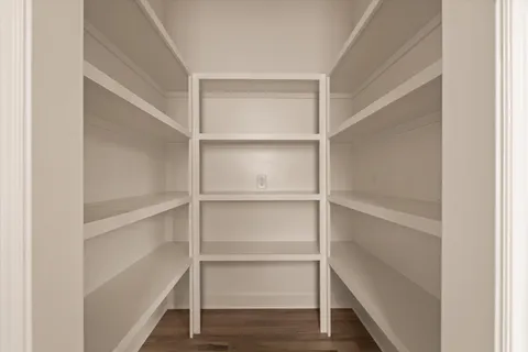 a view of walk in closet with wooden floor