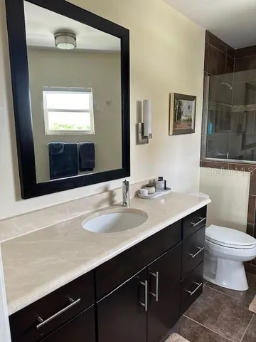 a bathroom with a sink a toilet a mirror and vanity