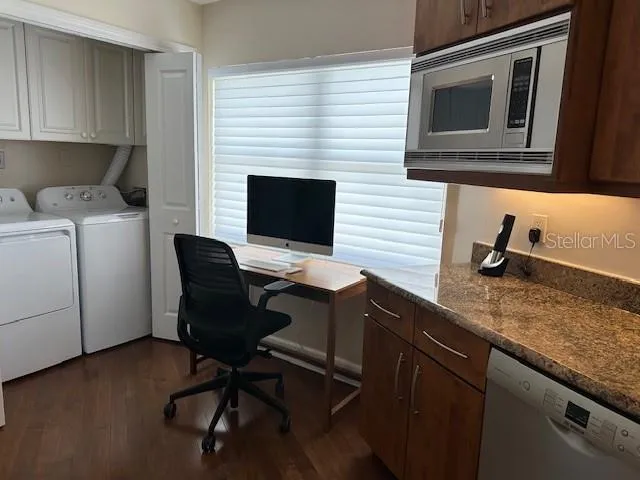 a view of a workspace with furniture and a window