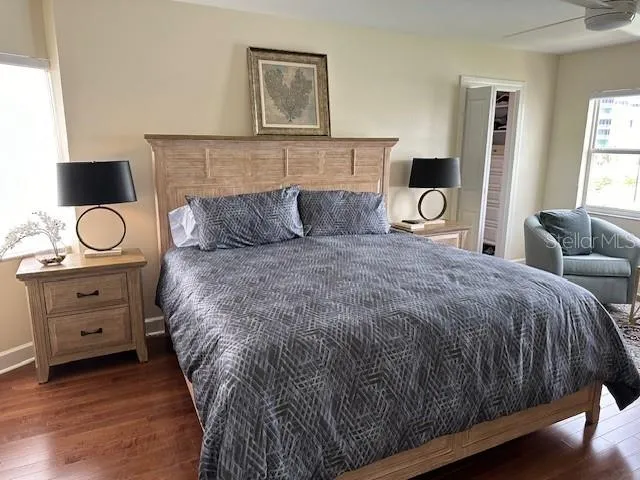 a spacious bedroom with a bed and wooden floor